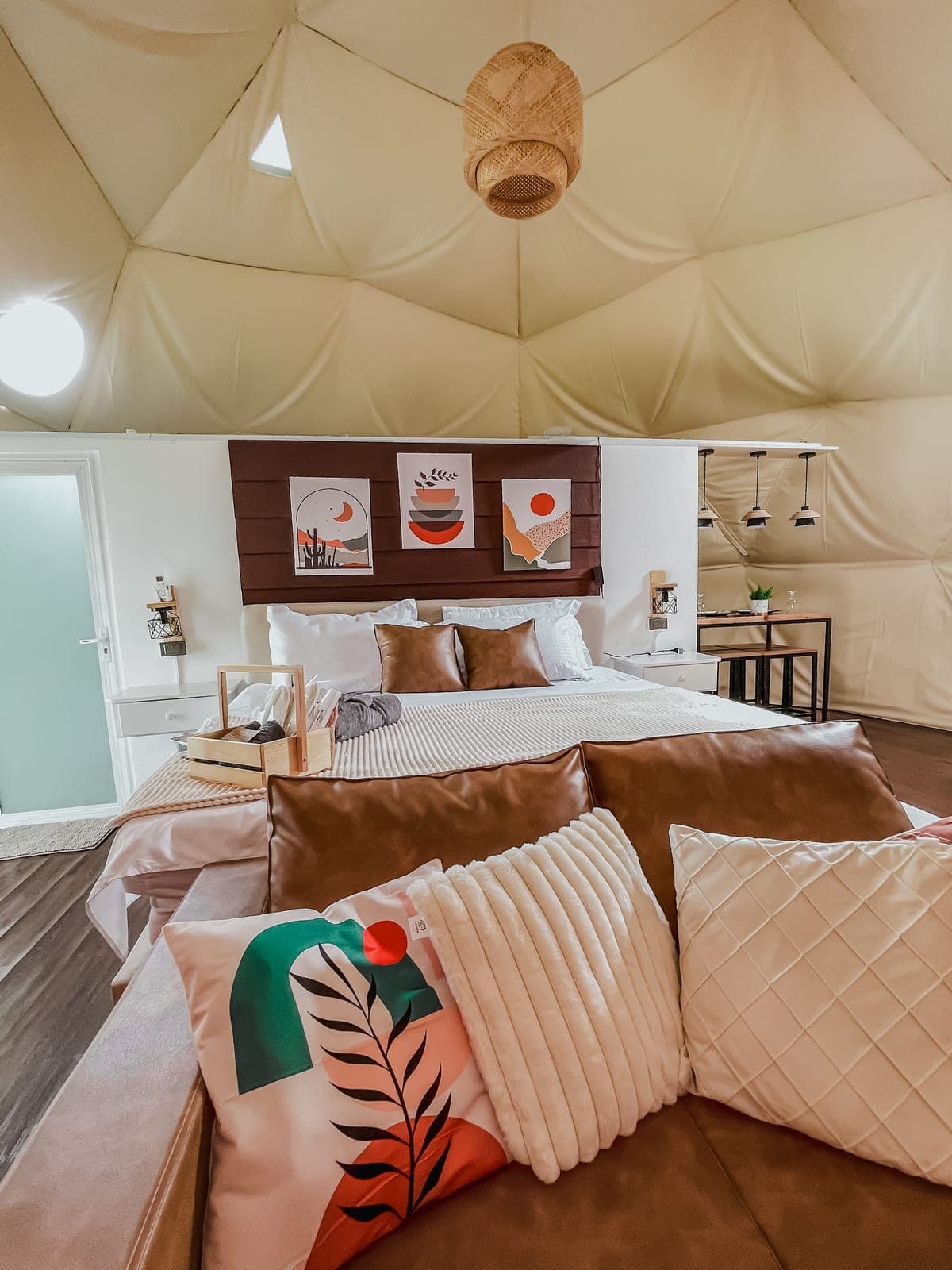 Dome 1 interior: a king bed in soft earth tones under the dome canopy