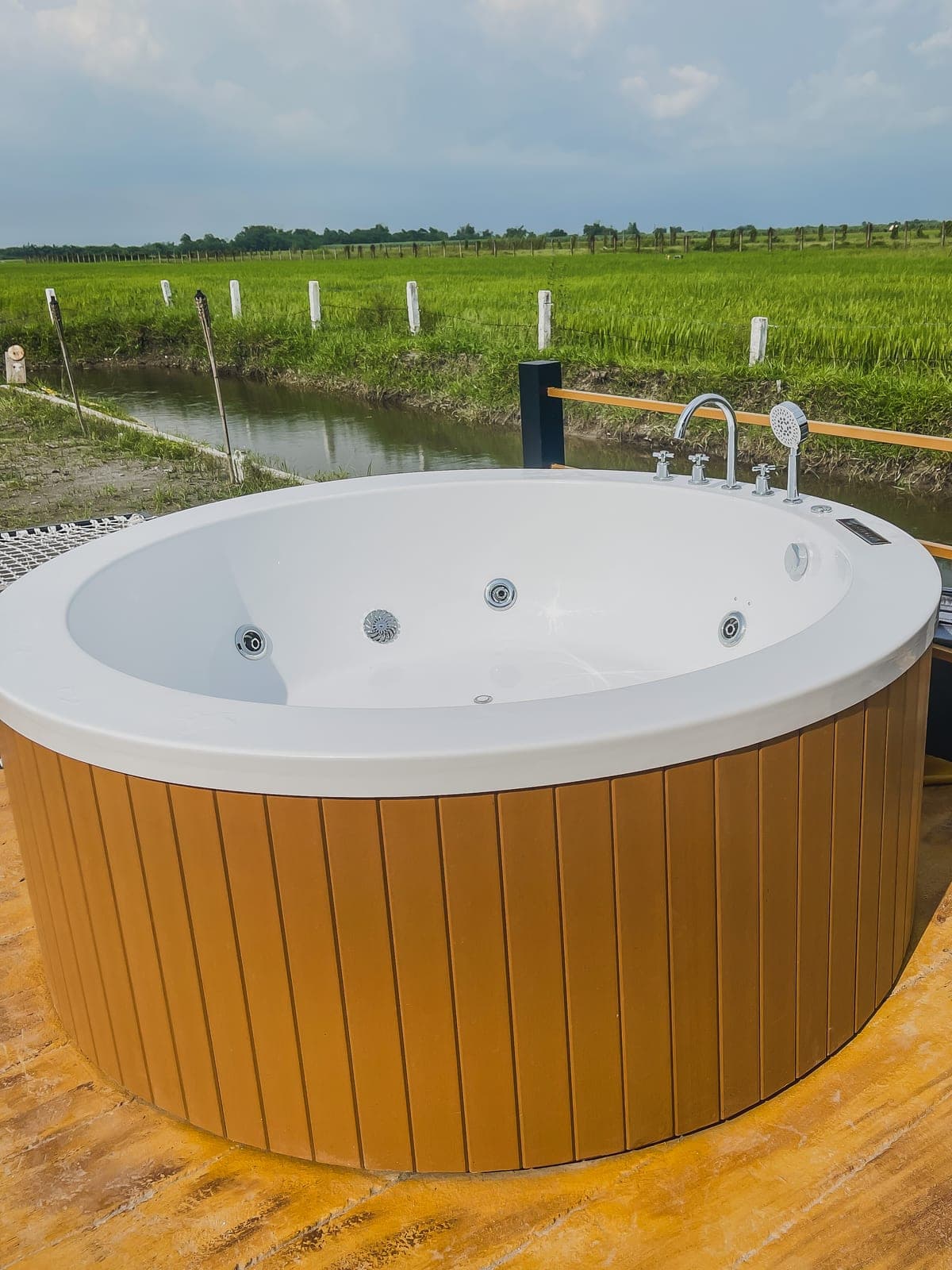 A heated jacuzzi on a deck overlooking rice fields