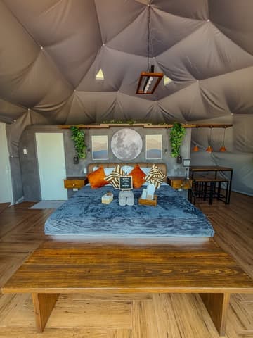Two king mattresses stacked on a wooden floor inside the dome
