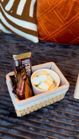 A s'mores kit with marshmallows and chocolate in a basket